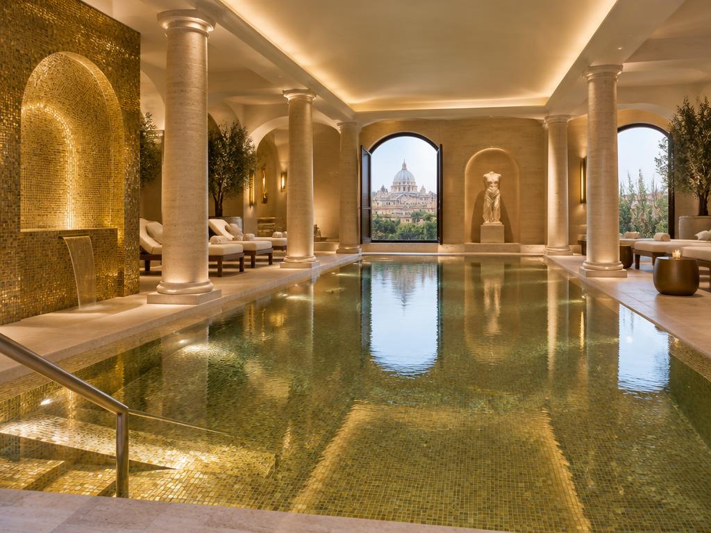 Indoor spa pool with gold mosaic tiles and travertine columns